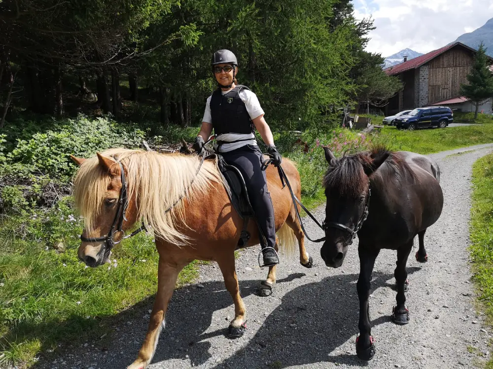 Claudia mit ihren Pferden beim Reiten im Sommer im Engadin